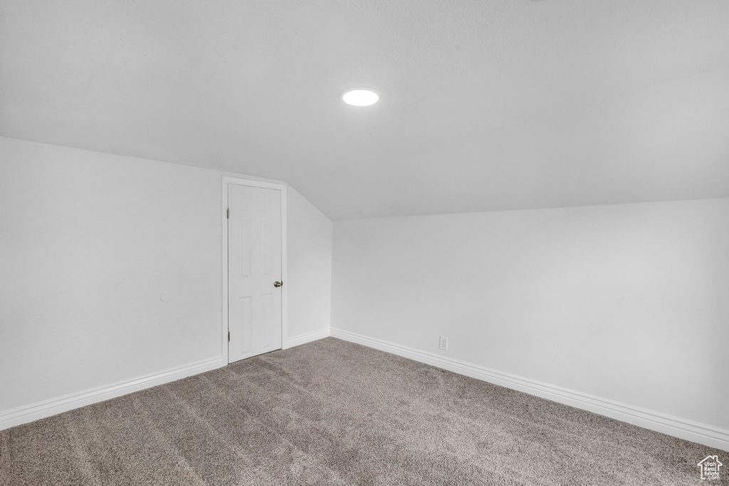 Bonus room featuring lofted ceiling and carpet