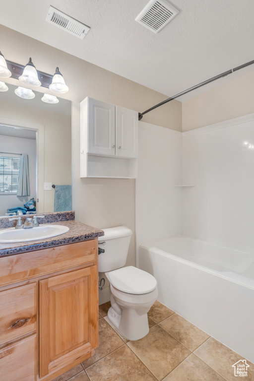 Full bathroom with toilet, tub / shower combination, a textured ceiling, vanity, and tile floors