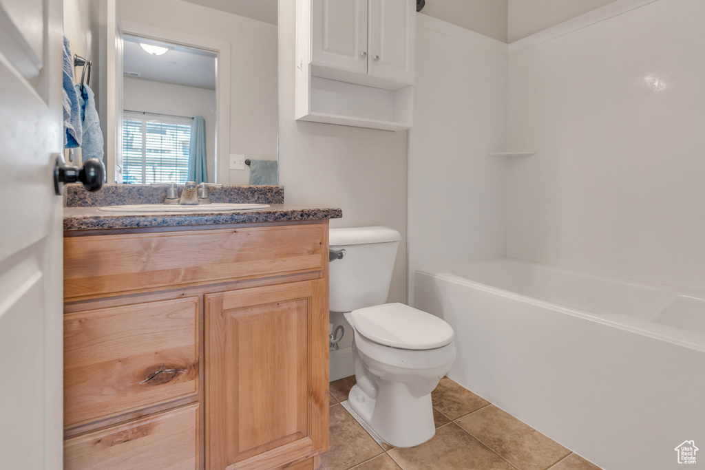 Full bathroom with tile floors, toilet, vanity, and shower / bath combination