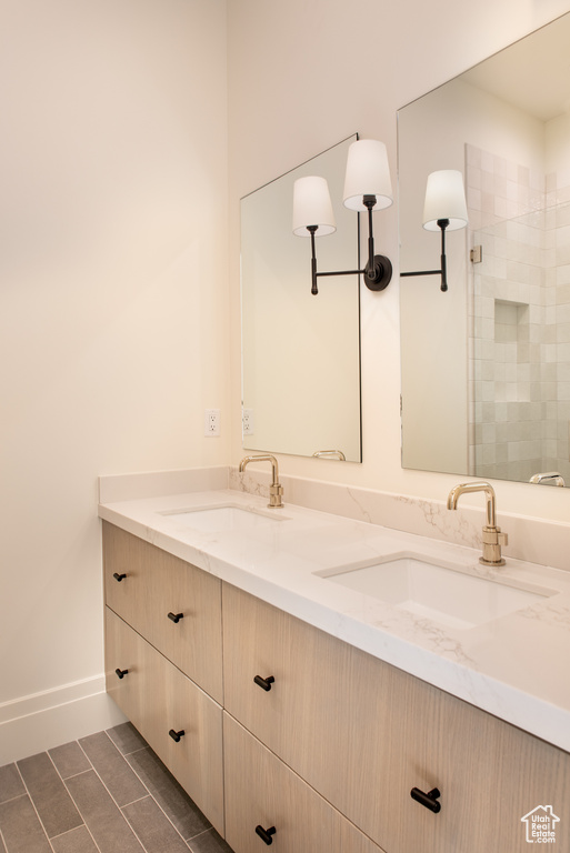 Bathroom featuring dual sinks, oversized vanity, and tile flooring
