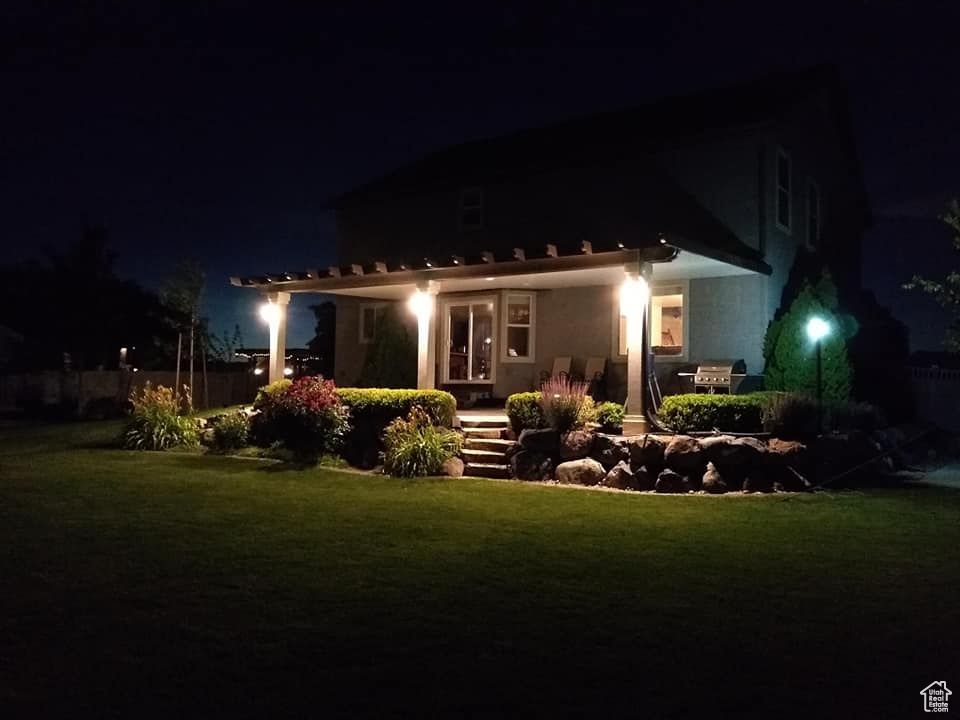 Back house at night with a lawn