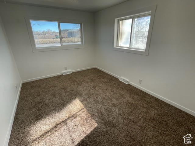 Unfurnished room with a healthy amount of sunlight and carpet