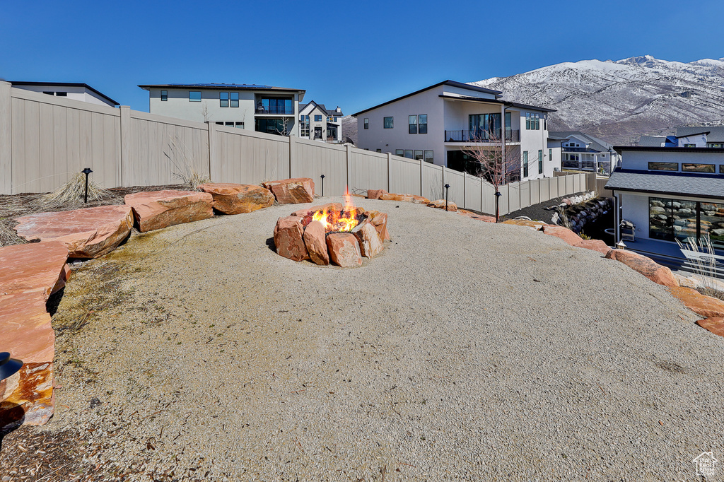 Exterior space with a fire pit, a balcony, and a mountain view