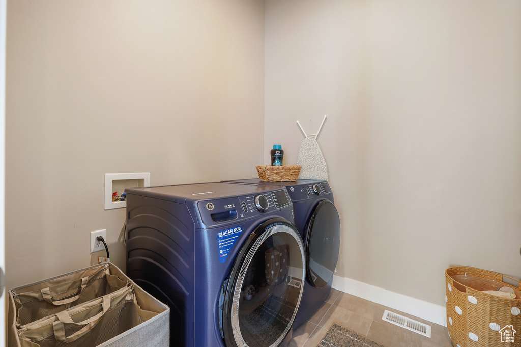 Laundry area featuring washer hookup, independent washer and dryer, and light tile flooring