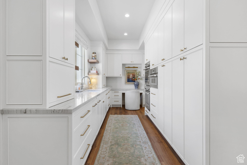 Kitchen featuring white cabinetry, dark hardwood / wood-style floors, and sink