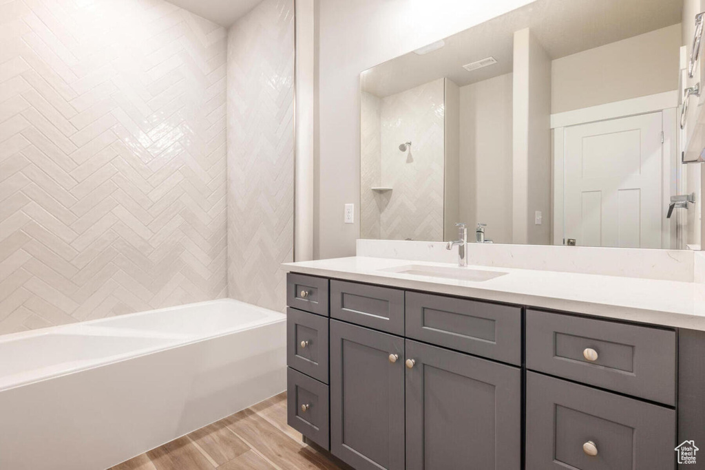Bathroom with  shower combination, vanity, and hardwood / wood-style floors