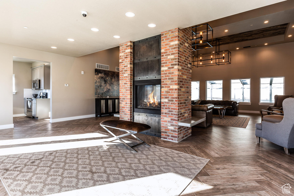 Living room with brick wall, dark parquet flooring, and a brick fireplace