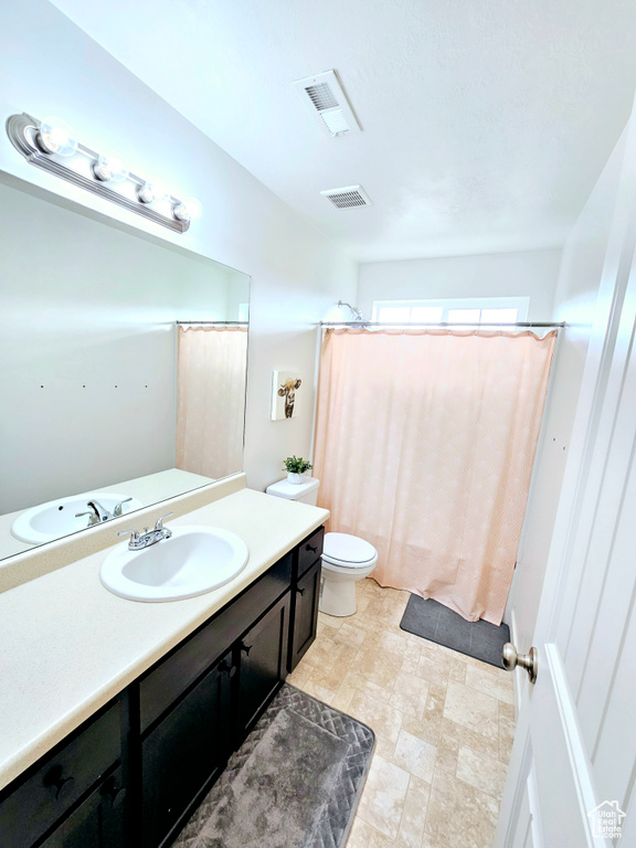 Bathroom with oversized vanity, tile flooring, and toilet