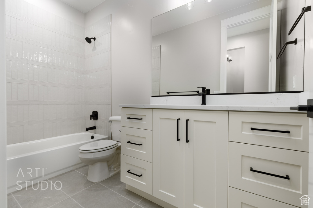 Full bathroom featuring shower / tub combination, tile floors, vanity, and toilet