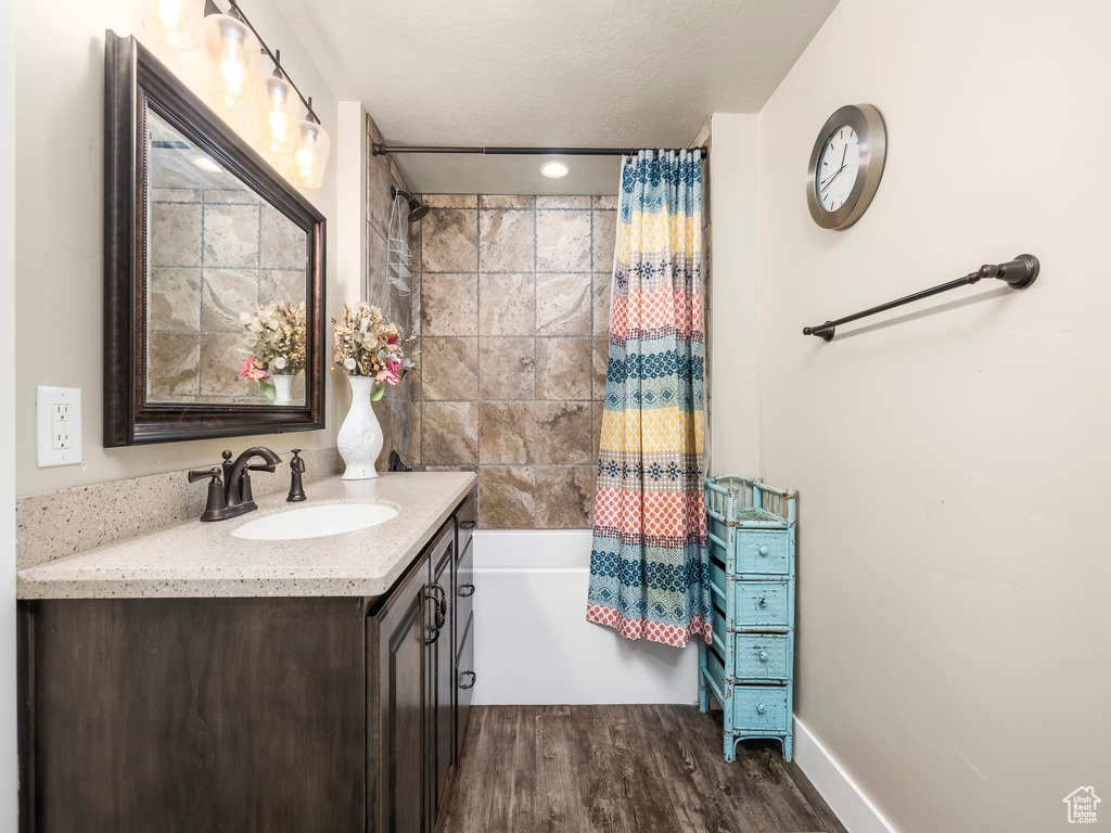 Bathroom with hardwood / wood-style flooring and vanity with extensive cabinet space