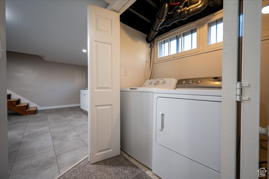 Washroom featuring independent washer and dryer and light tile floors