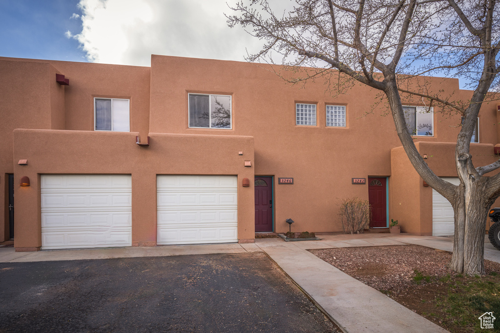 Pueblo-style home featuring a garage