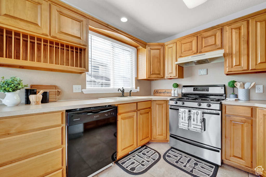 Kitchen with light tile floors, stainless steel range with gas cooktop, dishwasher, and sink