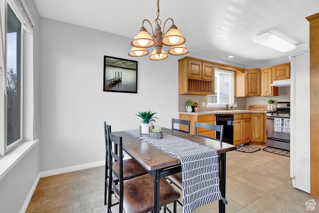 Kitchen with light tile flooring, stainless steel range oven, a notable chandelier, and dishwashing machine