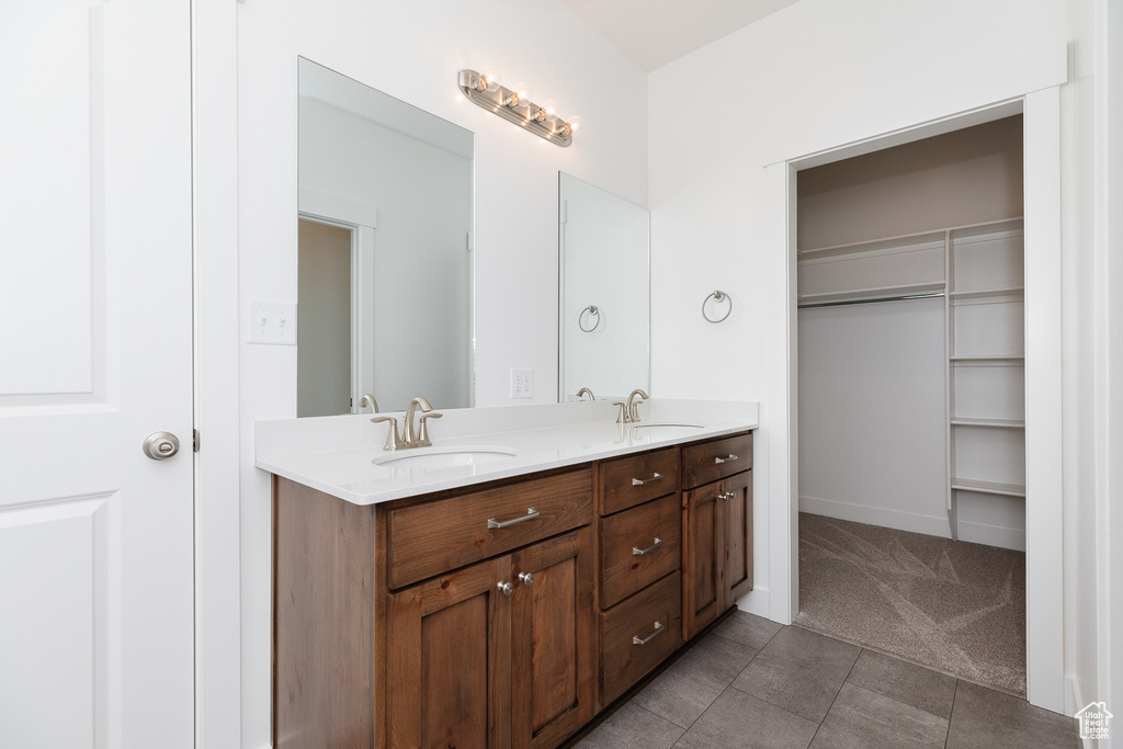 Bathroom featuring dual sinks, oversized vanity, and tile flooring