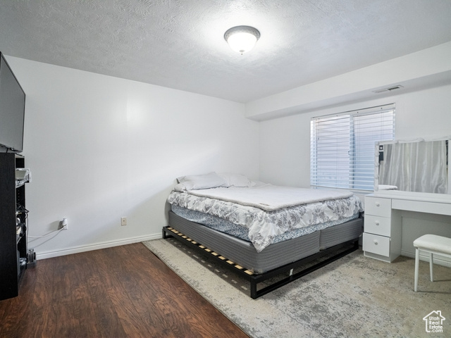 Bedroom featuring a textured ceiling and hardwood / wood-style flooring