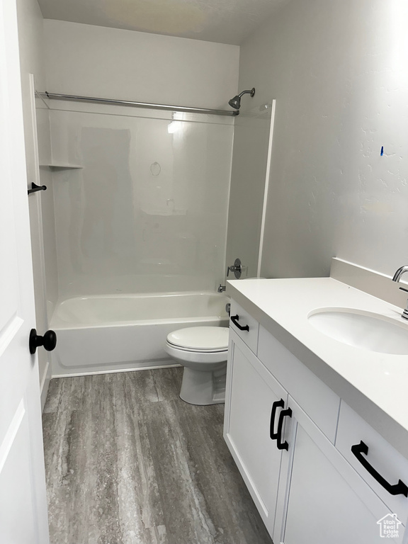 Full bathroom with hardwood / wood-style floors, bathing tub / shower combination, toilet, and vanity