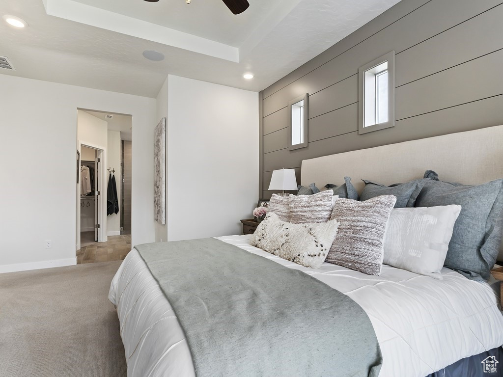 Bedroom featuring ceiling fan, light colored carpet, and a spacious closet