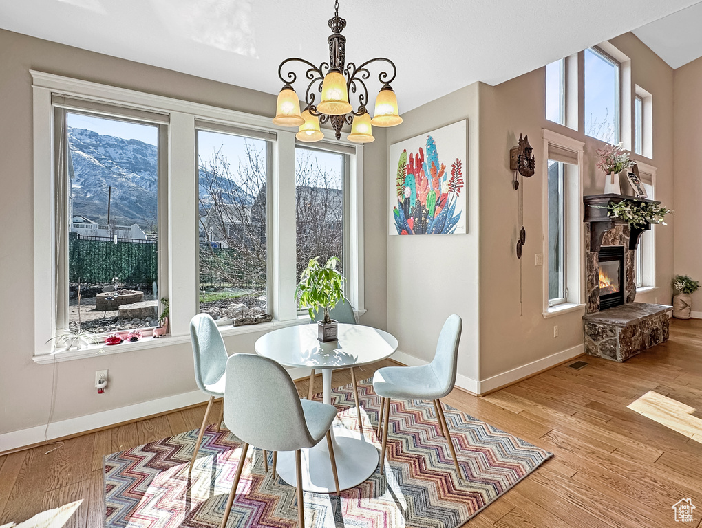 Dining space with a chandelier, a mountain view, light hardwood / wood-style floors, and a wealth of natural light