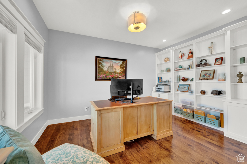Home office featuring built in features and dark hardwood / wood-style floors