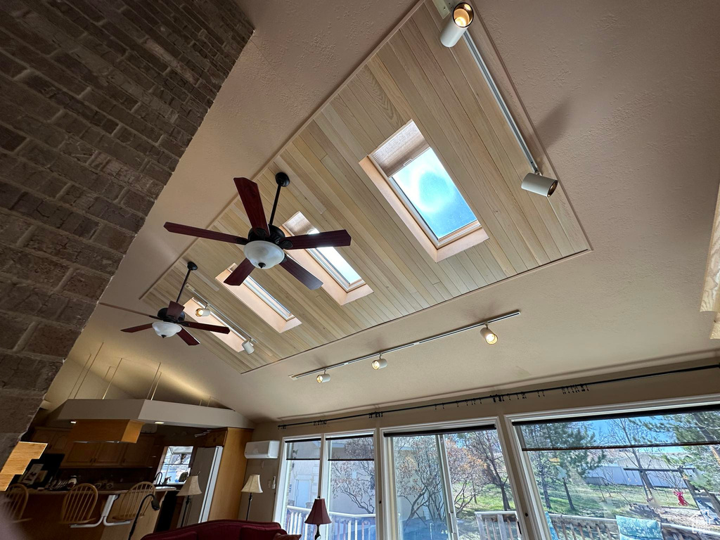 Details featuring ceiling fan, track lighting, a wall mounted air conditioner, and a skylight