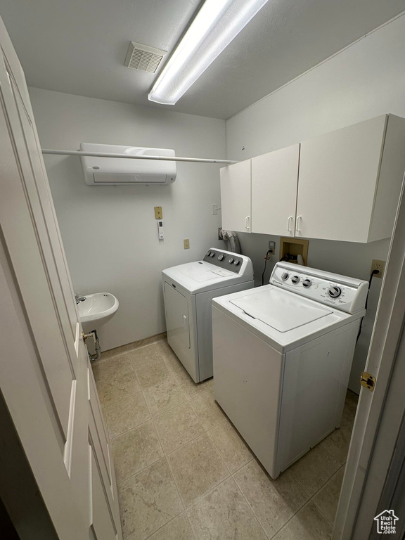 Laundry area with sink, light tile floors, hookup for a washing machine, cabinets, and washer and dryer