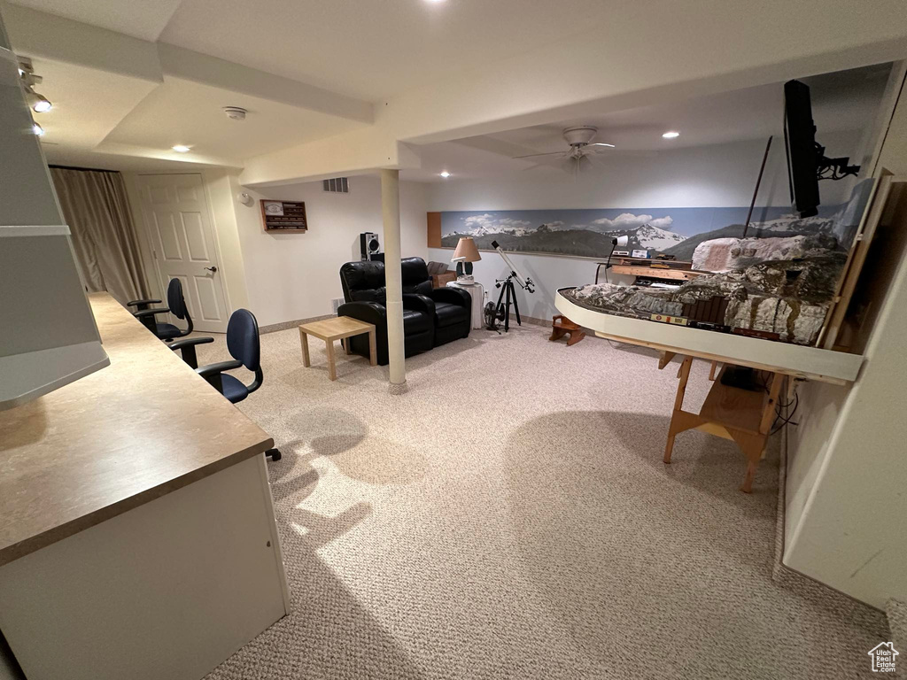 Home office with light carpet and ceiling fan