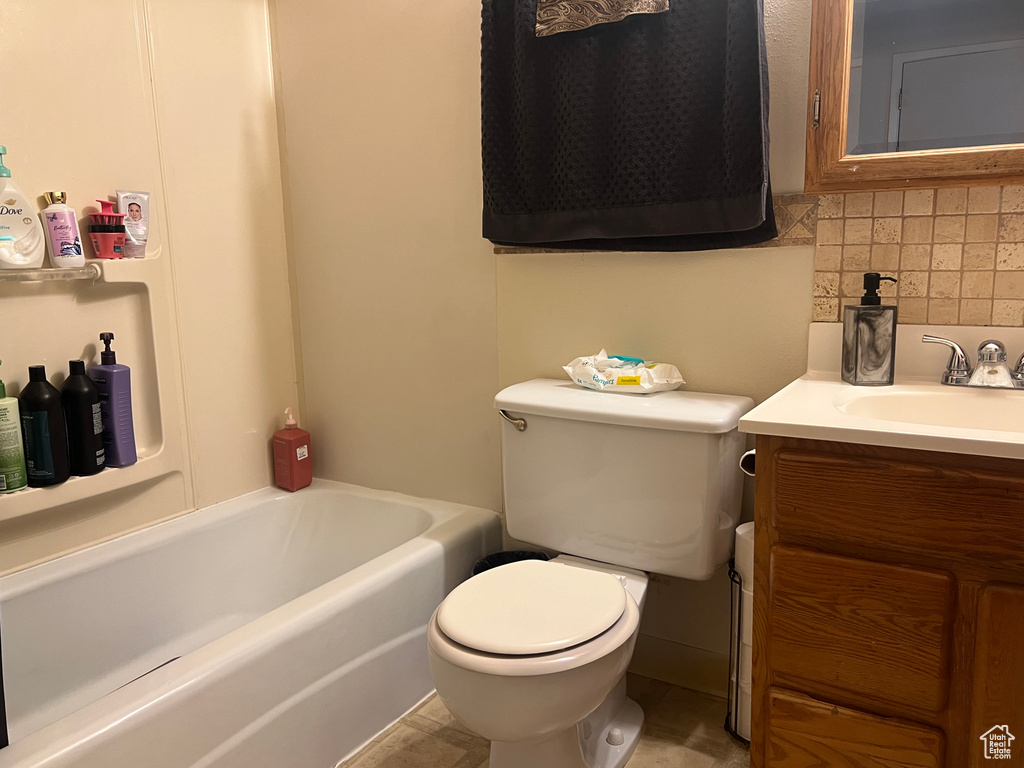 Full bathroom featuring tile floors, tasteful backsplash, toilet, vanity, and shower / bathing tub combination