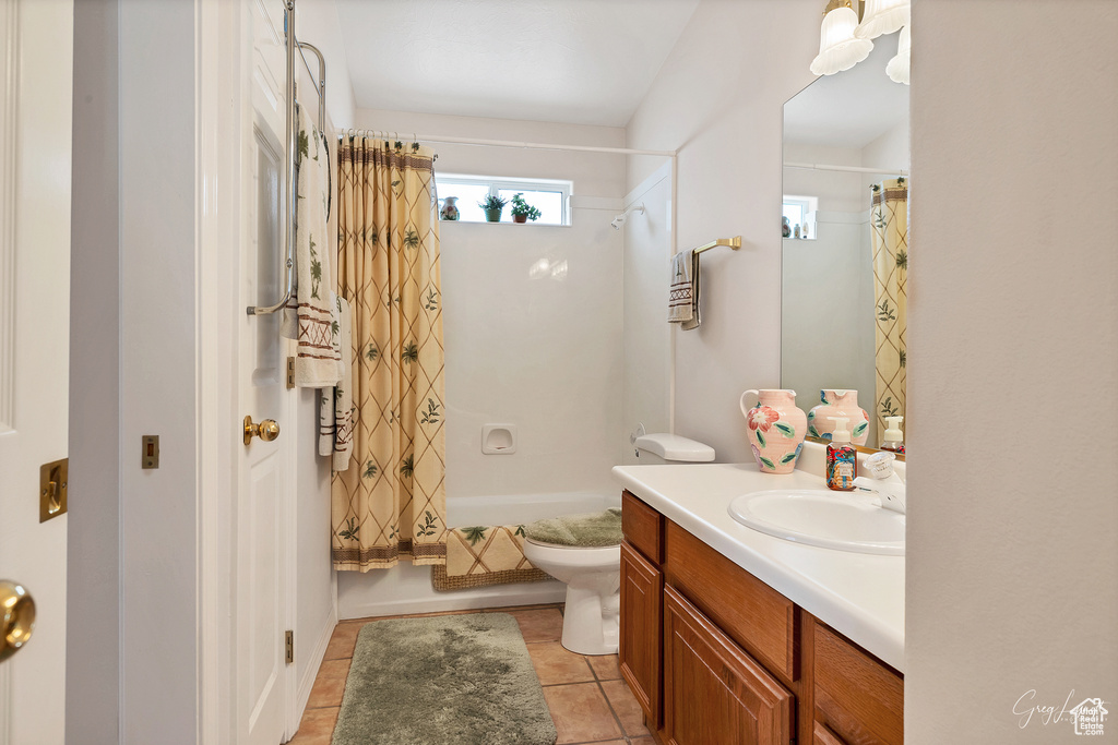 Full bathroom with vanity, tile floors, shower / tub combo with curtain, and toilet