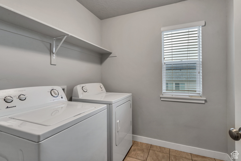 Laundry area featuring washer and dryer and light tile floors