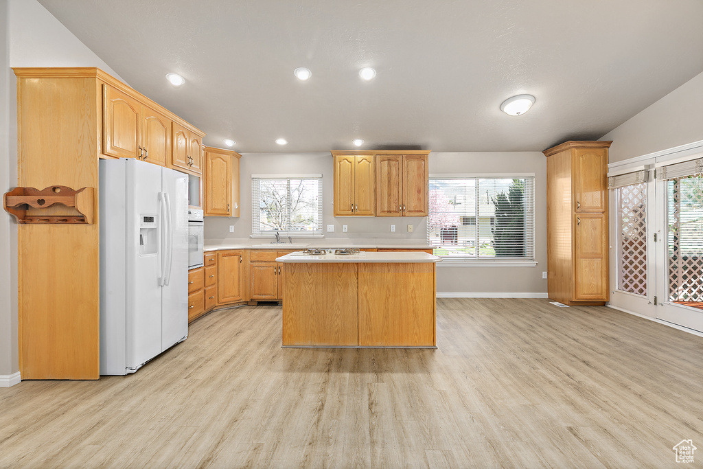 Kitchen featuring a healthy amount of sunlight, white appliances, and light wood-type flooring
