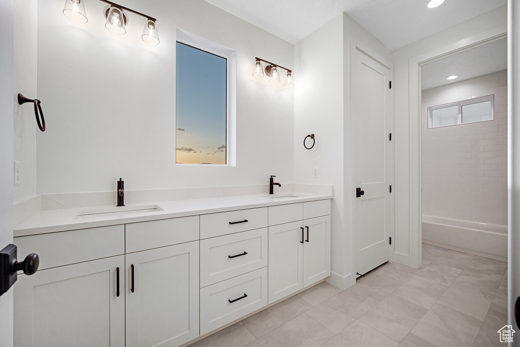Bathroom featuring plenty of natural light, tile floors, and double vanity