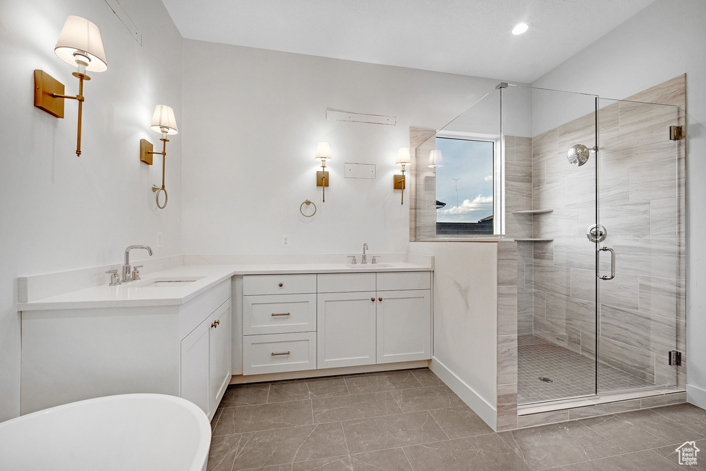 Bathroom with walk in shower, dual bowl vanity, and tile flooring