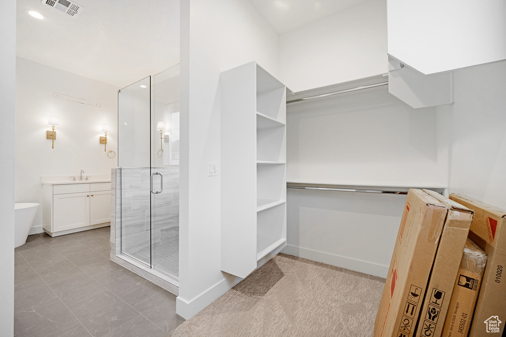 Spacious closet with light tile floors and sink