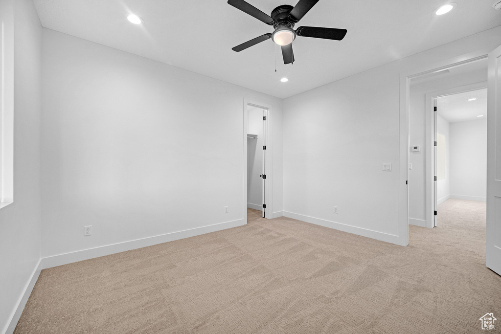 Unfurnished room with ceiling fan and light carpet