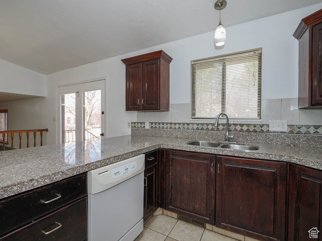Kitchen featuring backsplash, dark brown cabinets, light tile floors, sink, and dishwasher