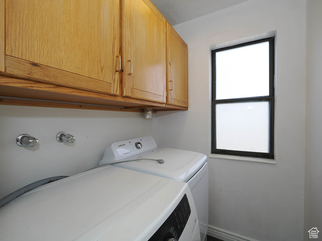 Laundry room featuring cabinets and washer and clothes dryer