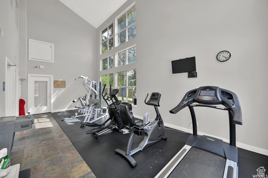 Gym featuring dark tile floors and high vaulted ceiling