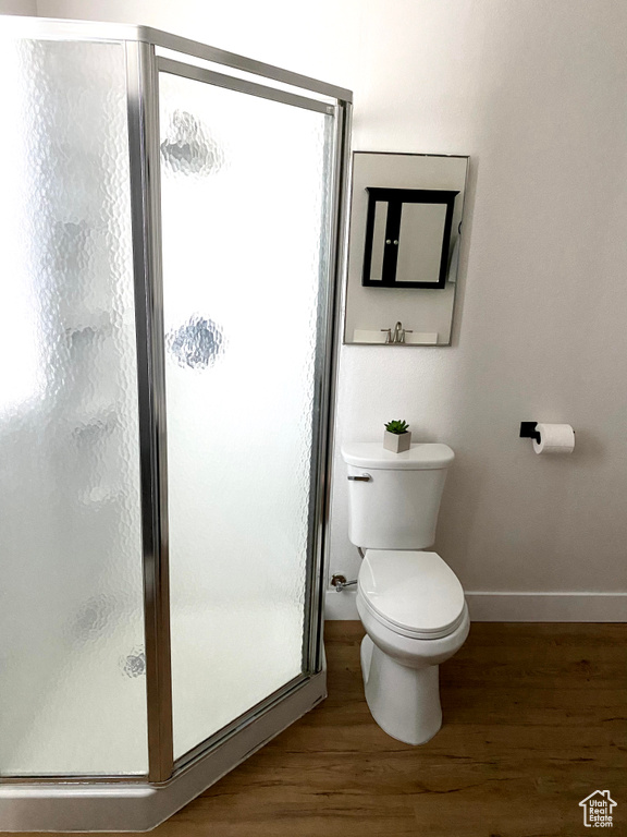 Bathroom featuring walk in shower, toilet, and hardwood / wood-style floors