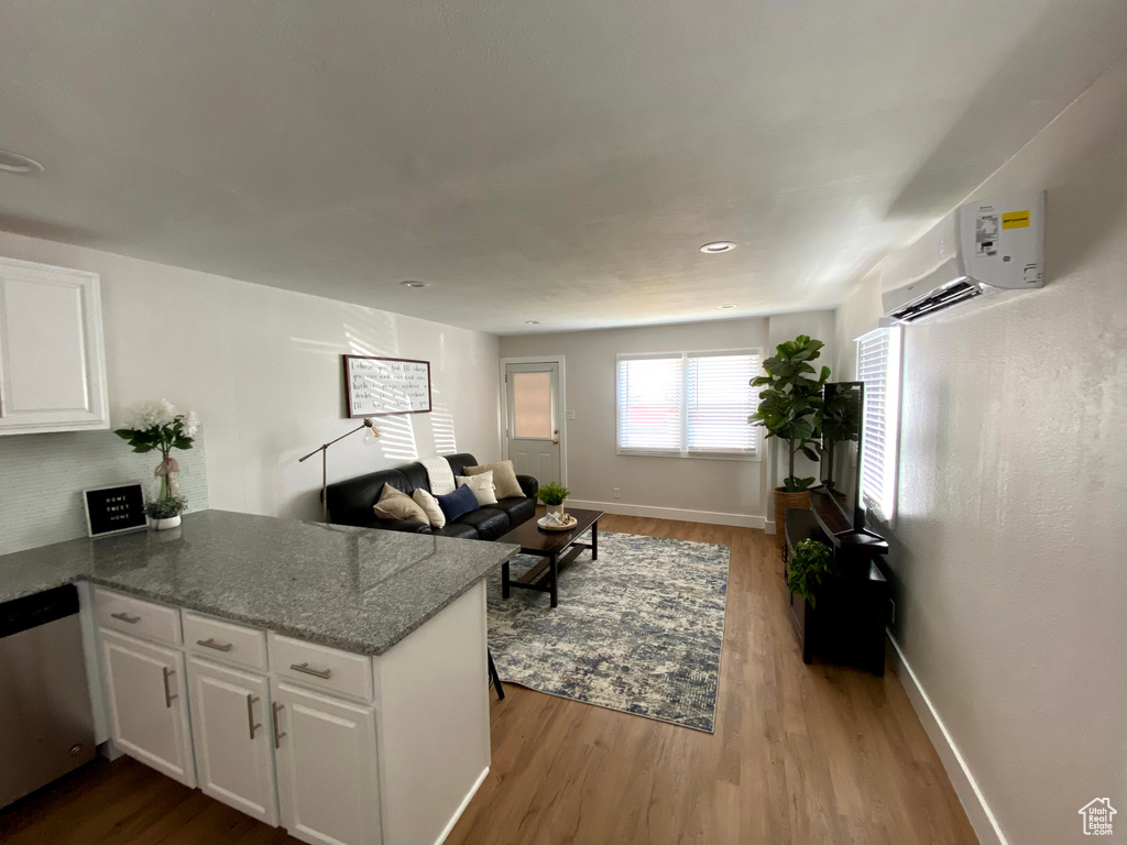 Living room featuring light hardwood / wood-style flooring and a wall mounted AC