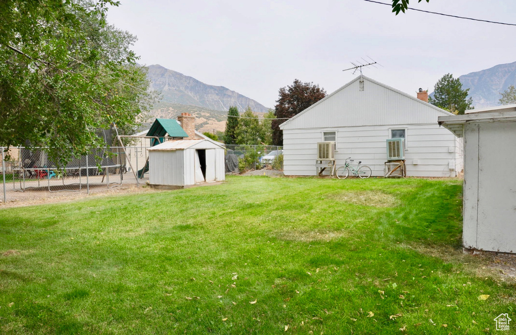 View of yard with a shed, a trampoline, and a mountain view