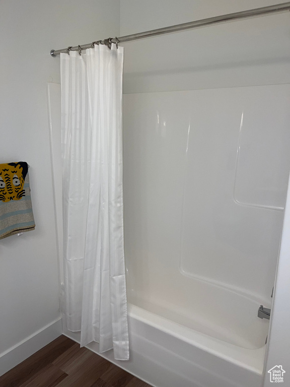 Bathroom with shower / tub combo with curtain and hardwood / wood-style floors