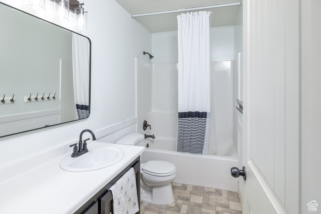 Full bathroom with vanity, shower / bath combination with curtain, tile flooring, and toilet