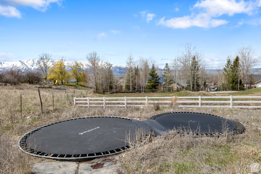 View of yard with a trampoline and a rural view