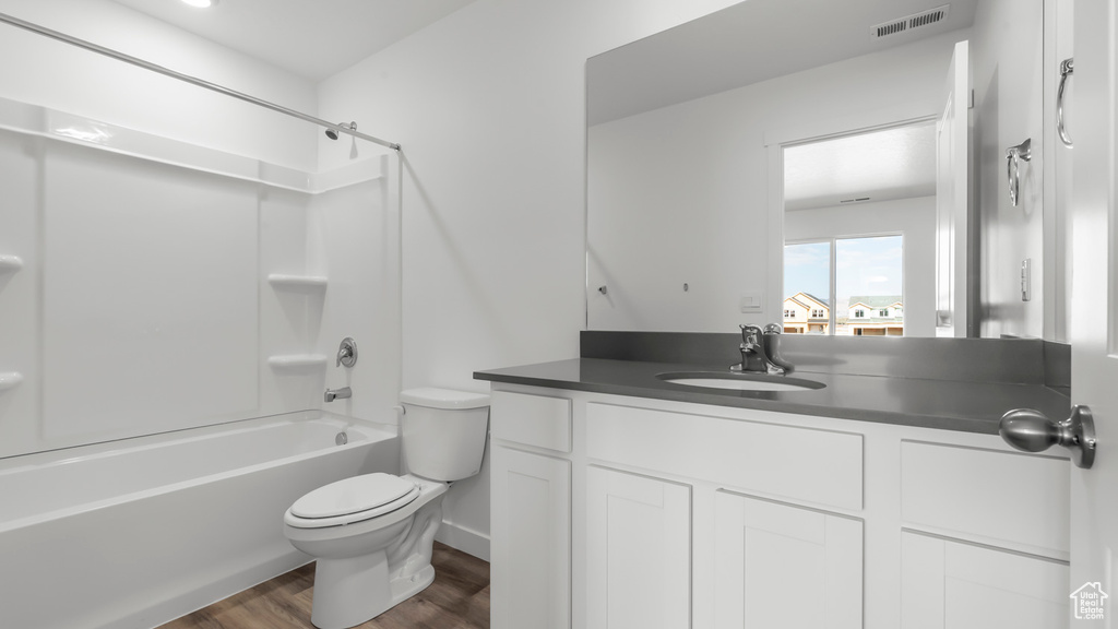 Full bathroom with toilet, vanity, shower / bathing tub combination, and hardwood / wood-style floors