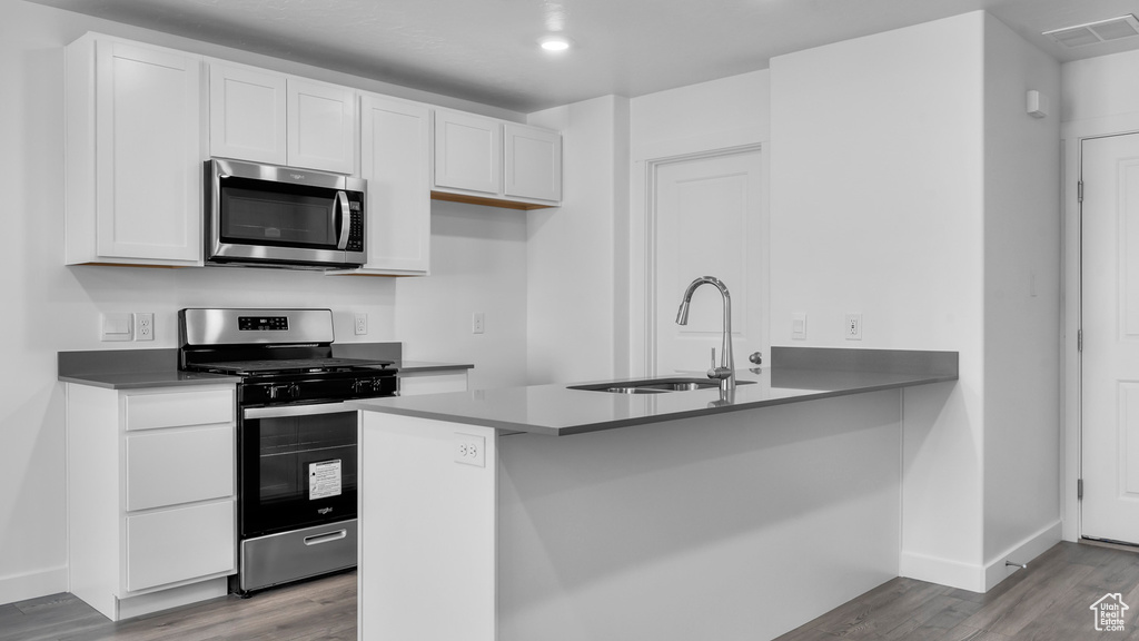 Kitchen featuring white cabinets, appliances with stainless steel finishes, light hardwood / wood-style floors, and sink