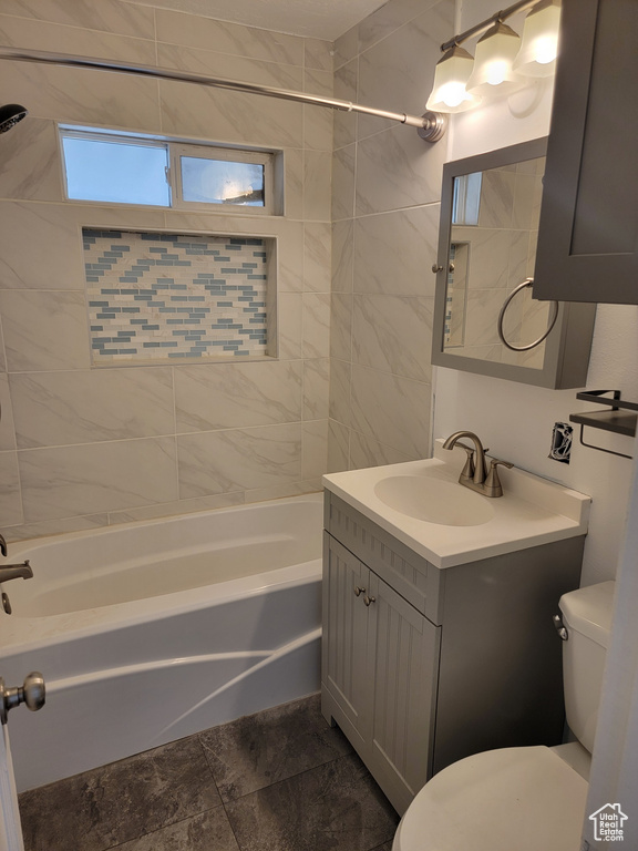 Full bathroom with vanity, tile flooring, toilet, and tiled shower / bath