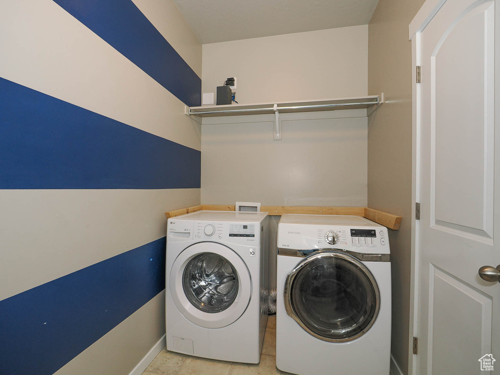 Washroom featuring hookup for a washing machine, washer and clothes dryer, and light tile flooring