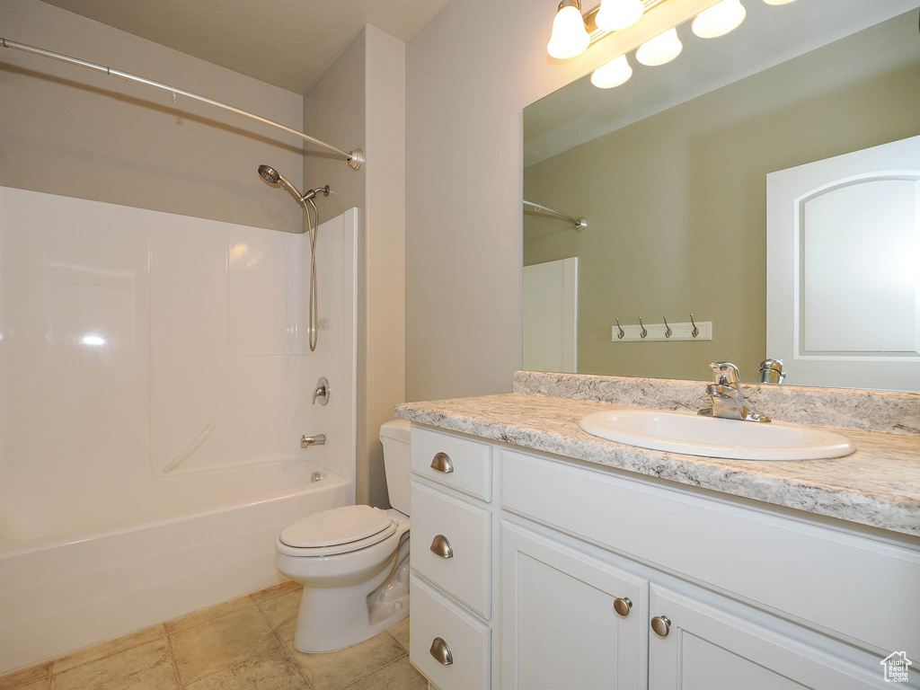Full bathroom featuring  shower combination, large vanity, tile floors, and toilet