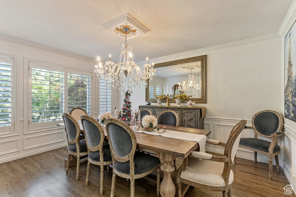 Dining room featuring a chandelier, dark hardwood / wood-style floors, and ornamental molding